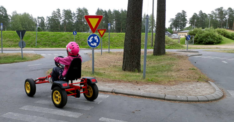 Lapsi ajaa liikennepuistossa kamerasta poispäin
