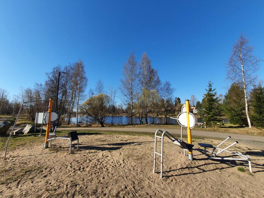 Aurinkoinen kevät päivä kuntoilulaitteita jokimaisemassa.