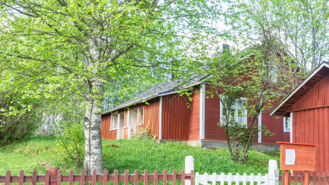 Mäkisessä pihapiirissä puinen museotalo ja piharakennus. Kuvan edustalla lauta-aita ja portti.
