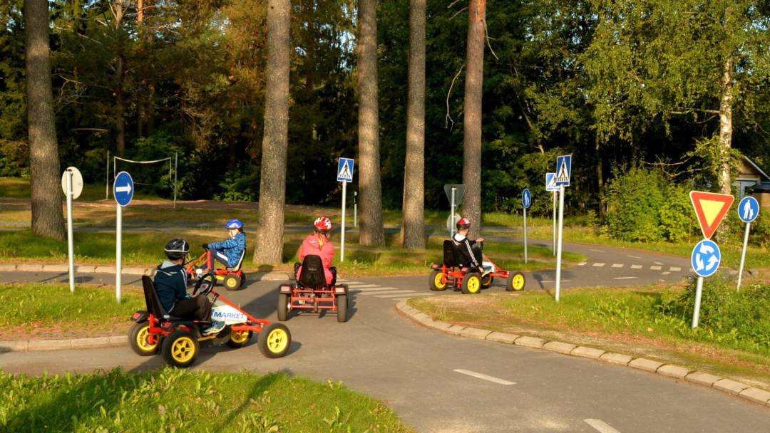 Lapsia ajaa liikennepuistossa polkuautoilla.