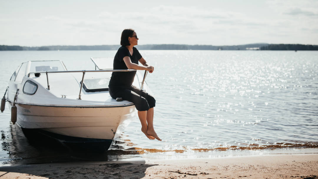 Nainen istuu veneen kannella .