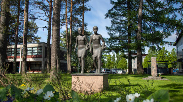 Mansikkatytöt -patsas. Kaksi nuorta tyttöä kävelee mansikkakorit kädessään.