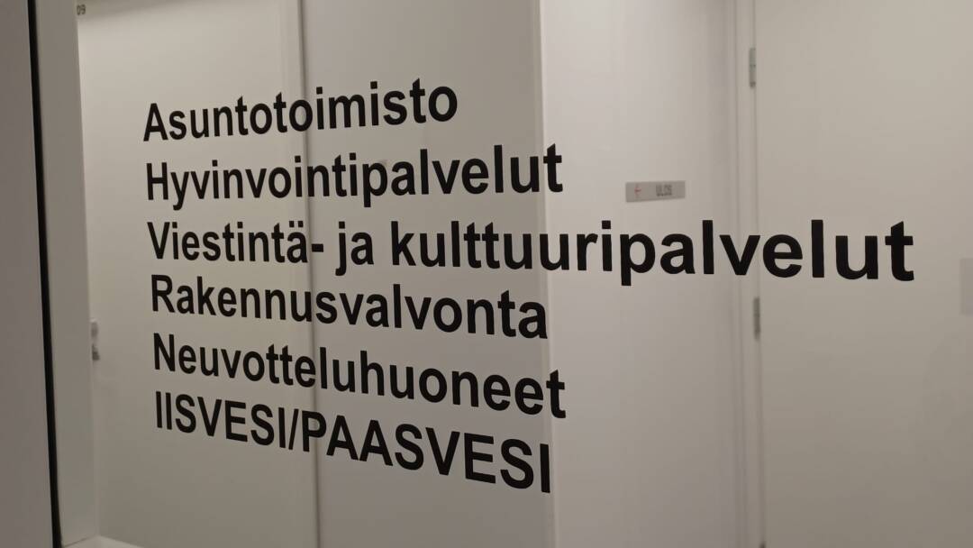 Virastotalon sisäoven ikkuna, jossa on tekstiä