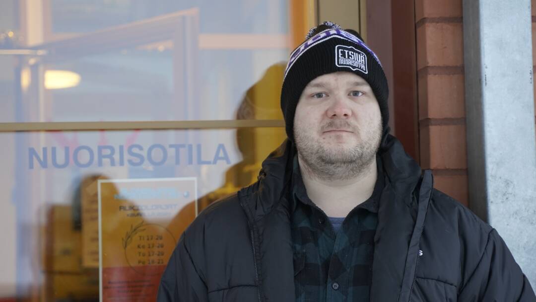Joonas Kononov seisoo oven edessä. Ovessa lukee nuorisotila.