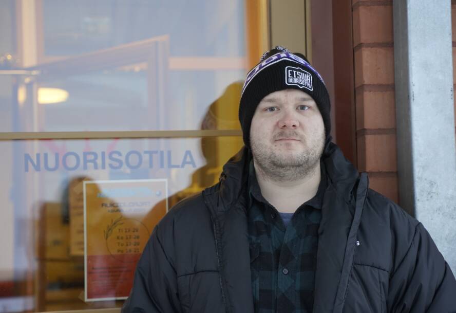 Joonas Kononov seisoo oven edessä. Ovessa lukee nuorisotila.