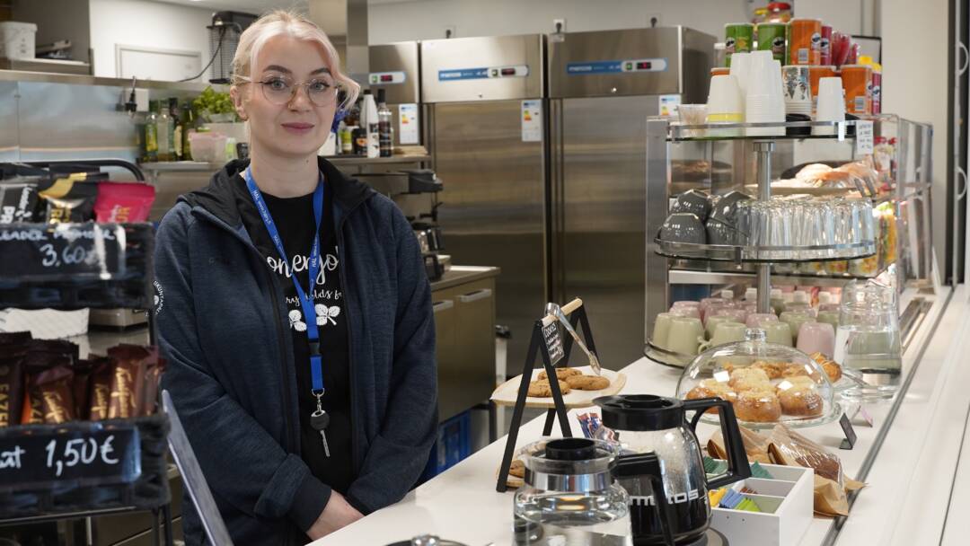 Nainen liikuntakeskuksen kahvilan myyntitiskin takana